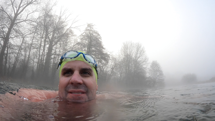 Simon swimming in a lake wearing swim hat and goggles